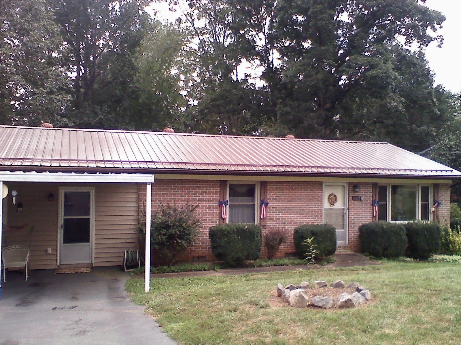 Bronze metal roof and carport on a brick ranch home — Roof Repair work by our crew in Pine Lake
